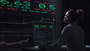 A stock broker working with a futuristic live global market display